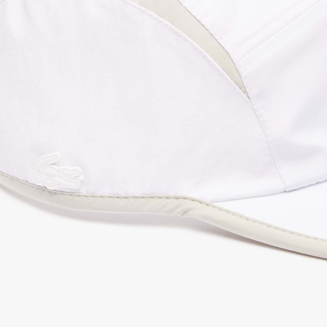 Accessories Lacoste Jockey Cap with Contrast Cutouts. ACTIVE MEETS NEO HERITAGE: SOFT AND HIGH END EXECUTIONS FOR A NEW BALANCED SILHOUETTE. Girolle active light visor with contrasted cuts on top and contrasted piping detail all around.- Recycled taffetas and recycled ripstop.- Unisex Taffetas lining inside.- Ajustable velcro back closure.- 2.5 cm silicone crocodile. Material: 100% Polyamide. Ref: RK1486IZ9.
