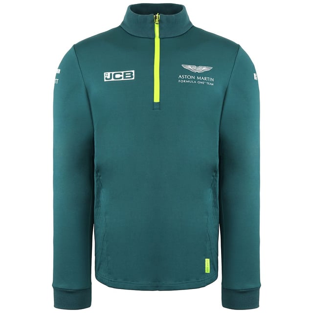 La camiseta Aston Martin F1 Official Team Men's Green Midlayer es una prenda elegante y funcional diseñada para los entusiastas de la Fórmula 1 y los seguidores del Aston Martin Cognizant F1 Team. Estas son las principales características de esta capa intermedia para hombre:

 Mercancía oficial del equipo:  Esta capa intermedia es mercancía con licencia oficial del equipo Aston Martin Cognizant F1, lo que garantiza que representa la marca y la calidad del equipo.

 Diseño verde:  La capa intermedia es predominantemente verde, lo que refleja el color característico del equipo y añade un toque deportivo y elegante a tu atuendo.

 Estilo de la capa intermedia:  Una capa intermedia suele estar diseñada para proporcionar una capa extra de calidez y comodidad sin ser demasiado voluminosa. Es ideal para llevar debajo de una chaqueta o encima de una camiseta.

 Marca del equipo Aston Martin F1:  La capa intermedia suele llevar la marca del equipo, incluidos logotipos y otros elementos asociados a la escudería de Fórmula 1, mostrando tu apoyo y pasión por el equipo.

 Cierre con cremallera: Suele incluir un cierre frontal con cremallera, que permite llevarla fácilmente y regular la temperatura.

 Construcción de calidad:  Los artículos oficiales de Fórmula 1 son conocidos por su calidad, y esta capa intermedia está diseñada para mantener su forma y estilo con el uso regular.

 Uso versátil:  Tanto si asistes a una carrera de F1 como si la ves desde casa o simplemente sigues con tu día a día, esta capa intermedia ofrece calidez y estilo, permitiéndote expresar tu pasión por el deporte y el equipo.

 Uso diario:  Aunque es perfecta para los eventos y carreras de F1, esta capa intermedia también es adecuada para el uso diario, añadiendo un toque deportivo y de moda a tu atuendo diario.