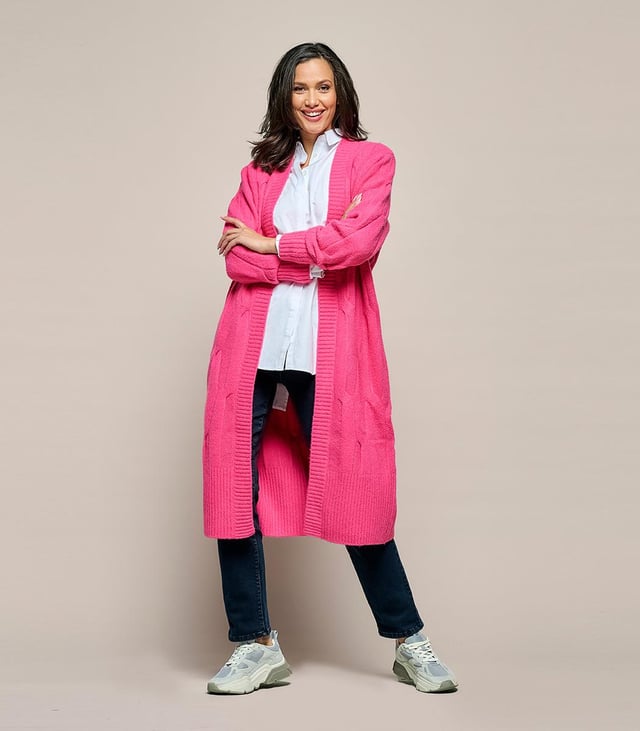 Het Chelsea kabelvest in een zachte roze kleur is een prachtig gebreid, lang vest met een openvallend ontwerp en robuuste ribboorden. Met een relaxte pasvorm die net boven de kuit valt, biedt dit vest een comfortabele en elegante uitstraling. Een afneembaar strikceintuur voegt een vleugje tailleaccentuering toe aan het geheel. Vervaardigd uit een wolmix van 47% acryl, 22% nylon, 20% wol, 8% alpaca en 3% spandex, biedt dit vest warmte en comfort, waardoor het ideaal is voor koude winterdagen. De combinatie van wol en alpaca verleent het vest een zachte en luxueuze textuur, terwijl acryl en nylon zorgen voor duurzaamheid en vormbehoud. De toevoeging van 3% spandex biedt een lichte stretch, wat resulteert in een comfortabele en flexibele pasvorm.Kortom, het lange roze Chelsea vest is een stijlvol en veelzijdig kledingstuk, met zijn losse snit, bijbehorende strikceintuur en prachtig gebreide ontwerp. De combinatie van diverse hoogwaardige materialen garandeert zowel comfort als stijl, waardoor het een uitstekende aanvulling is op je wintergarderobe. Het Chelsea vest biedt talloze mogelijkheden om verschillende stijlvolle en comfortabele outfits te creëren.Een suggestie is om het Chelsea vest te dragen over de Jesper travel top, samen met de Indy travel broek in een opvallende kobaltkleur. Het contrasterende kobaltblauw voegt een levendige dimensie toe aan het roze vest, wat zorgt voor een sprankelende outfit. Je kunt ook het Chelsea lange vest combineren met de Cassidy tuniek in een veelkleurig patroon, samen met de zwarte legging. Het levendige en kleurrijke patroon van de tuniek creëert een boeiend contrast met het effen roze vest. Eveneens kun je het roze kabelvest succesvol combineren met de Audrey print blouse. Onthoud dat jouw comfort en zelfverzekerdheid in je kledingkeuze centraal staan. De combinatie van de roze tint en het sprankelende, veelkleurige patroon geeft je outfit een krachtige en vrolijke uitstraling.
