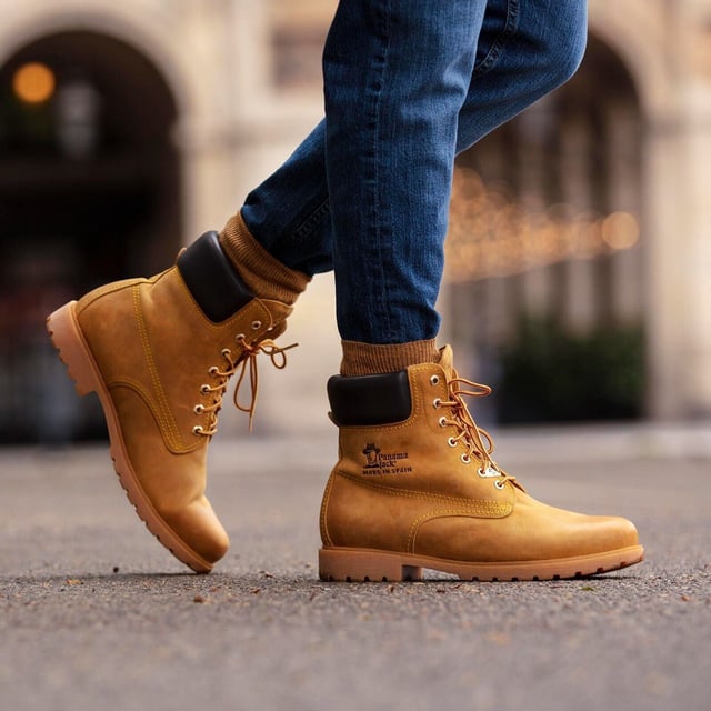 Steigen Sie mit Stil und Komfort aus mit Panama Jack-Stiefeln. Egal, ob Sie über schroffe Landwege wandern oder durch städtische Straßen navigieren, der originale Panama Jack 03 C1 Herren-Schnürstiefel ist Ihr perfekter Begleiter. Diese Stiefel zeichnen sich durch ein klassisches Design mit einer schlichten runden Spitze und einem dunkelbraunen, gepolsterten Lederkragen aus und strahlen zeitlose Eleganz aus. Die kontrastierenden roten und gelben Schnürsenkel sorgen für einen Farbtupfer, während die genähte karamellfarbene Commando-Sohle für Strapazierfähigkeit und Stabilität in jedem Gelände sorgt. Für die Herren sind die Schnürstiefeletten Tan Panama Jack 03 für Herren so konzipiert, dass sie den Elementen standhalten. Mit einem wasserdichten, glatten Nubuk-Obermaterial, einem weich gepolsterten Knöchelschaft und einem warmen Futter halten diese Stiefel Ihre Füße kuschelig und trocken. Das geprägte Logo an der Ferse und die silbernen sechseckigen Metallösen verleihen ihrem robusten Charme einen Hauch von Raffinesse. Hauptmerkmale: Klassisches Design: Die Panama 03-Stiefel vereinen Design, Qualität und Komfort nahtlos und bieten eine zeitlose Ästhetik für Männer und Frauen. Vielseitiger Tragekomfort: Egal, ob Sie die Straßen der Stadt erkunden oder Bergpfade erobern, diese Stiefel sind perfekt für alle Ihre täglichen Abenteuer. Wasserdichte Konstruktion: Diese Stiefel sind aus wasserdichtem Vintage-Nappaleder mit Lederfutter gefertigt und sorgen dafür, dass Ihre Füße bei jedem Wetter trocken und bequem bleiben. Anatomische Unterstützung: Genießen Sie verbesserten Komfort und Hygiene mit der anatomisch geformten Innensohle, die eine perfekte Passform für Ihre Füße bietet. Langlebig und rutschfest: Die Gummiaußensohle bietet Flexibilität, Haltbarkeit und rutschfeste Traktion und sorgt für Stabilität auf verschiedenen Oberflächen. Hergestellt in Spanien: Mit einer Schafthöhe von 18 cm werden diese Stiefel fachmännisch in Spanien gefertigt, um höchste Handwerkskunst und Qualität zu gewährleisten. Schlüpfen Sie in die Stiefel von Panama Jack und erleben Sie die perfekte Mischung aus Stil, Haltbarkeit und Komfort für Ihre alltäglichen Abenteuer. Diese Stiefel wurden für diejenigen entwickelt, die Wert auf Qualität und Handwerkskunst legen. Sie sind Ihr vertrauenswürdiger Begleiter, wohin auch immer Ihre Reise Sie führt.
