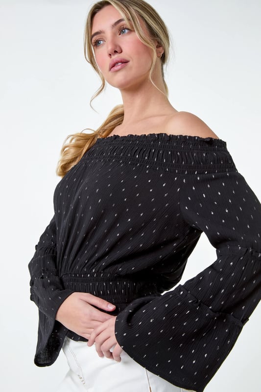Shimmer Foil Textured Bardot Top from Roman. Shimmer into the new season with this metallic foil print bardot top. With its off-the-shoulder neckline and tiered sleeves, it exudes effortless Summer elegance. Made from a crinkle woven fabric, this top will keep you cool and comfortable on warm days with its relaxed bardot finish. The shirred stretch neck and waist provide a flattering fit, while the frill hem adds a feminine touch. Pair it with matching wide leg trousers (18061508) from our Dusk Collection for a chic and coordinated look or with denim jeans for casual Spring looks.
