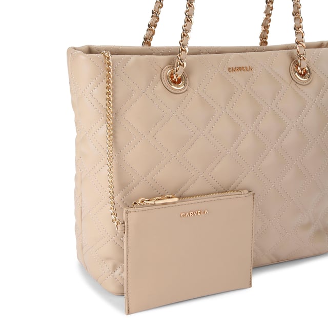 This Carvela Rosa Chain Tote Bag features a taupe leather alternative exterior with diamond quilting detail. There are two shoulder straps which have gold chain detail to match the branding on the front of the bag. Dimensions: 29cm (H), 34cm (L), 12cm (D). Strap length: 57cm.