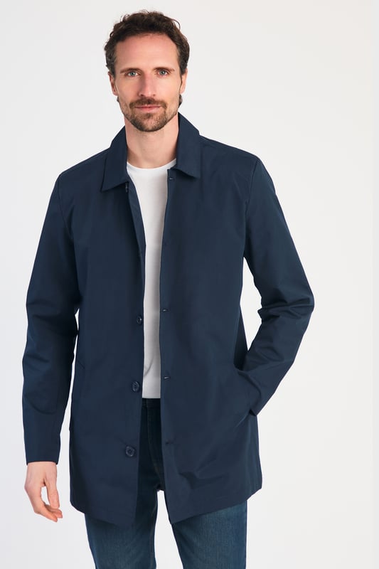 This men's mac-style coat from Kensington Eastside features a classic collar, button-up fastening, and a mid-length cut for a sleek, modern look. Lightweight and stylish, it’s perfect for layering over both casual and formal outfits, making it a versatile wardrobe essential for effortless style.