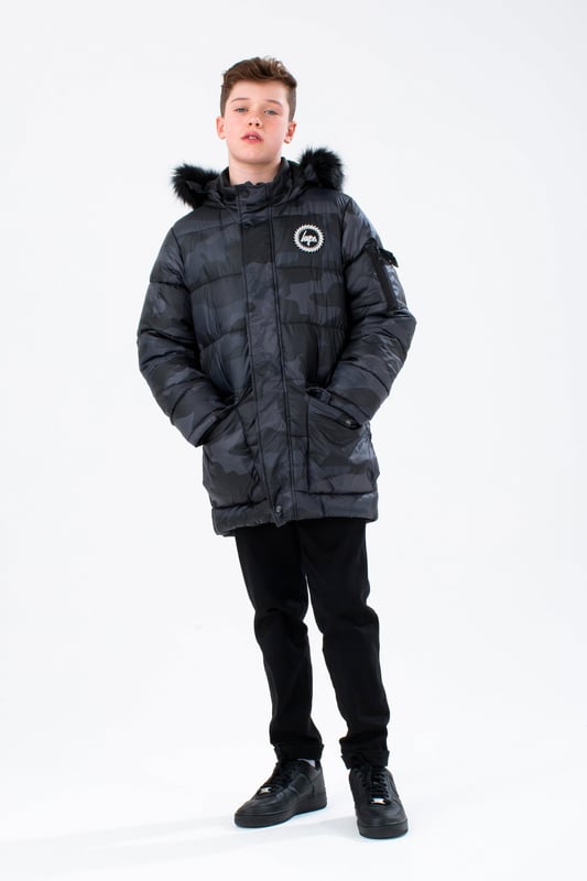 Imagine a completely versatile jacket that features both the parka and puffer style. Meet the HYPE. Kids Camo Explorer Jacket, part of the HYPE. 2022 Back to School collection. Designed in our standard unisex explorer parker shape, in our signature camo print in khaki and brown. Finished with an arm pocket and embossed justhype logo zip puller and a faux fur brown neutral hood trim. Machine wash at 30 degrees to keep in new condition.