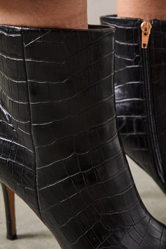 Sleek pointed toe design for a sophisticated silhouette
        Textured faux leather with a chic crocodile-inspired pattern
        Stiletto heel measuring between 7-9cm for an elegant boost
        Ankle-length style with a side zip for easy wear
        Versatile day-to-night boot suitable for various occasions
    
    The Corsica Pointed Stiletto Ankle Boots from Wallis are the epitome of versatile glamour. These striking boots showcase a refined pointed toe and a sleek stiletto heel, perfect for the woman who appreciates sophistication with a modern edge. The textured faux leather exterior adds a touch of luxury, while the crocodile-inspired pattern lends an air of exotic allure. Ideal for transitioning from day to evening, these boots can be styled with tailored trousers and a crisp blouse for a polished office look, or paired with a flowing midi dress for an elegant dinner ensemble. The ankle-length cut offers flexibility in styling, working beautifully with both trousers and skirts. Whether you're heading to an important meeting or a night out with friends, these Wallis boots will ensure you step out in style and confidence.