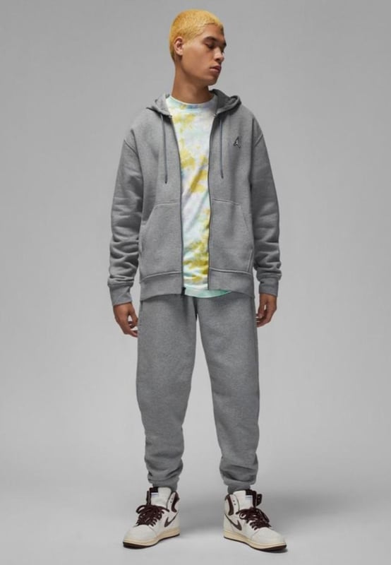 Der Nike Jordan Essential Fleece-Trainingsanzug ist Ihr neues Alltags-Essential. Der vielseitige Fleecestoff ist ideal für die Herbstsaison und bietet den perfekten Hintergrund für das Jumpman-Wappen und die charakteristische Stickerei auf dem Kapuzenpullover und der Jogginghose. Kapuzenpullover und Jogginghose mit elastischem Kordelzug. Der schwere Fleecestoff ist auf der Innenseite gebürstet und sorgt so für zusätzliche Weichheit. Elastische Rippbündchen an Bündchen und Saum. Jordan Standard-Passform.