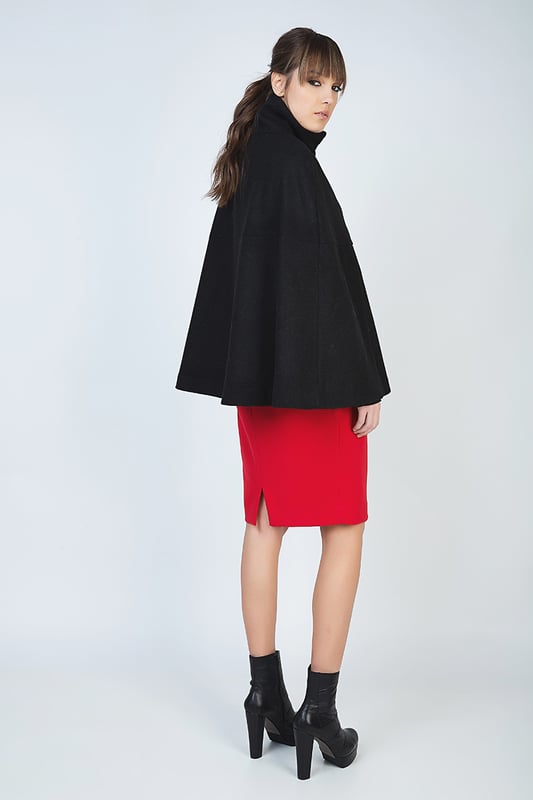 Winter cape in black woven fabric. Fastens in the front with a decorative black plastic zip. Upright colour. Openings for the arms under the bust. Loose fit. Fully lined in black woven fabric. Our model has height 178 cm and wearing size 36. Measurements for size 38 (in cm):Bust-66; Body length-68; Waist-86; Hemline-96. Garment is loose fitted.