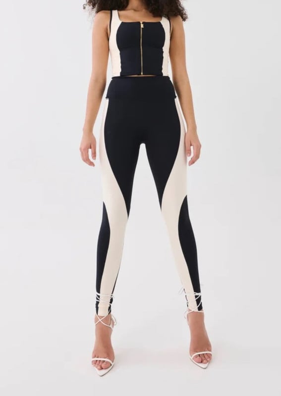 A high-rise full length legging cut in a soft compressive matte blend of recycled nylon and elastane. With built in waistband support, this style is ideal for low impact training and your street-sport wardrobe. A contrast beige curved panel detailing throughout and a P.E Nation silicon badge at the ankle for a minimal finish.