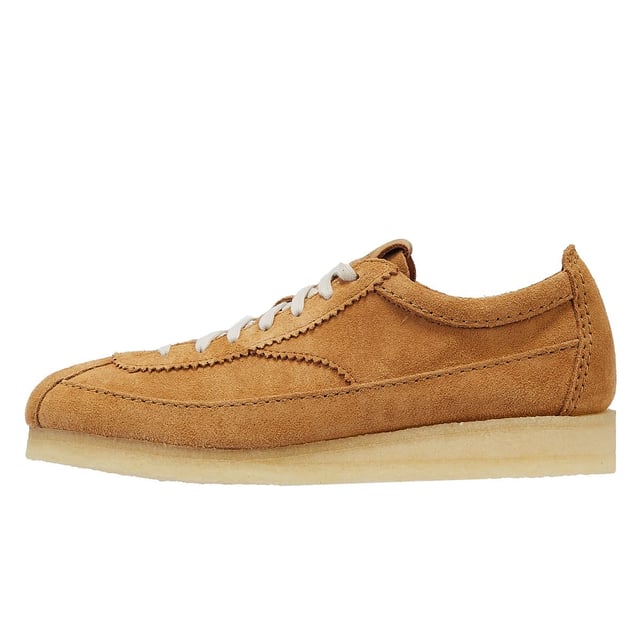 Introducing a premium mid-tan suede upper shoe with a sleek trainer silhouette, featuring tonal top-stitch details, complemented by a comfortable crepe sole. Finished with two Clarks Originals fobs.