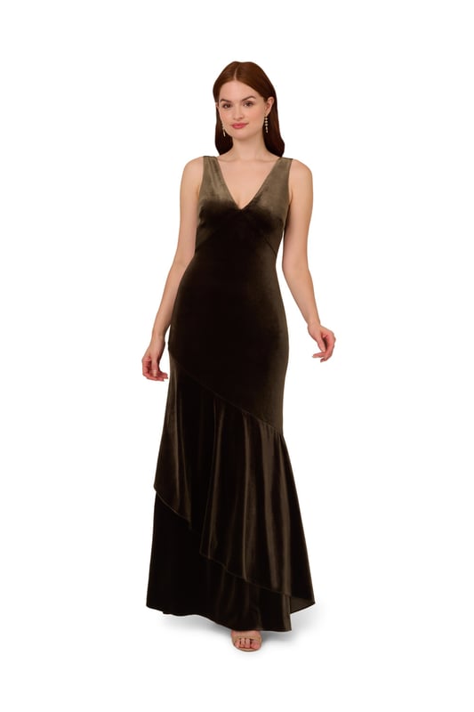 Elegant details elevate this velvet mermaid gown for the season. This formal dress features a sleeveless bodice, v-neckline, is fitted through the body, and contrasted by a mermaid skirt with a ruffled hem. Designed with a soft yet shining velvet fabric, this mermaid gown is elevated by a cowl back with a zipper closure at the centre back. Styled with nude high heels and a beaded clutch, this sleeveless velvet gown