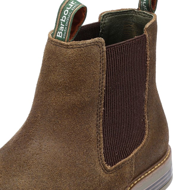 Der Farsley Chelsea Boot hat ein Obermaterial aus Wildleder und eine Zugschlaufe mit dem Barbour-Logo. Die Gummisohle mit Holzpaneel-Details ist mit einer robusten, zementierten Konstruktion an das Obermaterial geklebt und sorgt für maximale Haltbarkeit und Komfort.