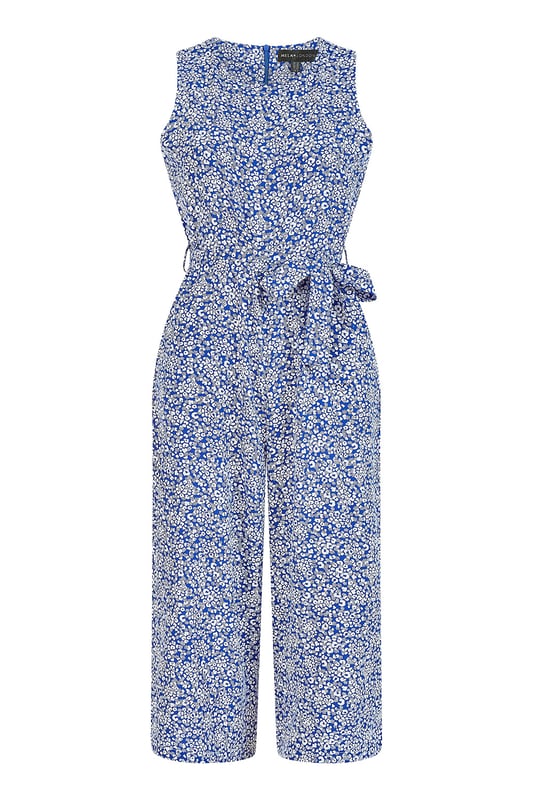 This summer is all about cute prints and this Mela Blue Ditsy Printed Jumpsuit delivers on all counts. Featuring a dainty white floral ditsy print, this piece is designed to flatter all shapes and sizes. Check the waist accentuating self tie belt and elegant, wide legged culotte. Match with a cropped denim jacket and chunky white trainers to complete the look.