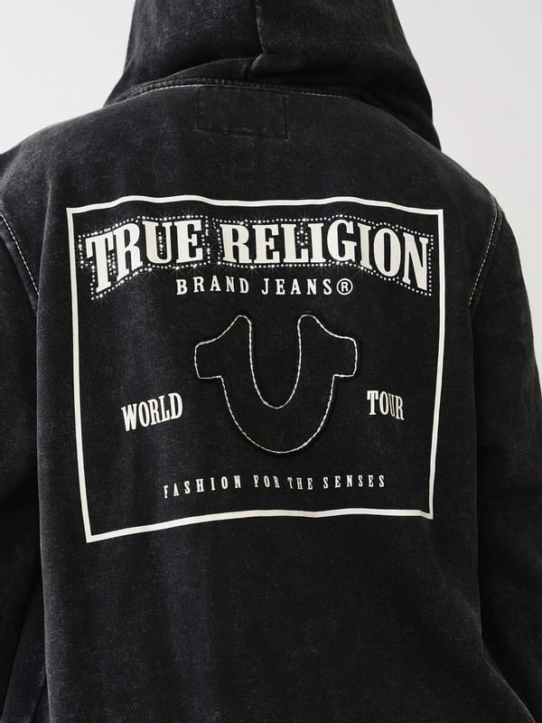 Get cozy in the Acid Wash Big T Boyfriend Zip Hoodie. Crafted from soft, fleece-lined knit, this hoodie features a vintage acid wash, zip-up front, drawstring hood, split kangaroo pocket, and dropped long sleeves. Finished with horseshoe appliques, Big T stitching, and a back True Religion World Tour logo.
