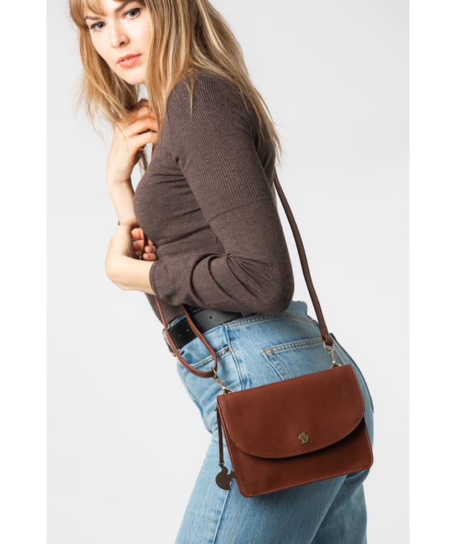 The 'Cara' cross body clutch bag from Conkca London is handcrafted from multi-toned leather for a beautiful finish. A magnetic press-stud secured cover opens to reveal the spacious interior that is lined with natural and untreated 100% cotton and includes two slip pockets. A full-width slip pouch on the rear of the bag is ideal for on-the-go storage. It comes with an adjustable leather strap with a maximum drop length of 70cm which is removable, converting the bag into a clutch bag. Adorned with the inimitable Conkca squirrel charm and metal logo.