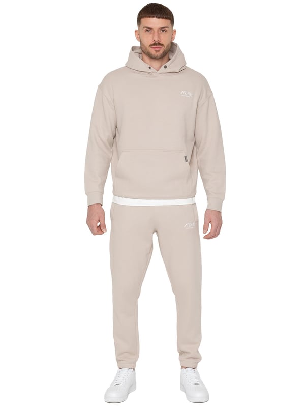 Presentamos el Conjunto de Chándal con Sudadera con Capucha Oversized Averè para Hombre de Enzo Milano, una mezcla perfecta de comodidad y estilo. Este set incluye una Sudadera con Capucha Oversized con un suave forro de felpa, un logotipo sutil en el pecho, un diseño audaz en la parte trasera y una capucha con botones a presión. Los Joggers de Corte Regular tienen una cintura elástica, cordones ajustables, bolsillos laterales y puños acanalados en los tobillos para un ajuste seguro. Ideal para relajarse o para salidas casuales, este chándal ofrece un estilo relajado y a la moda