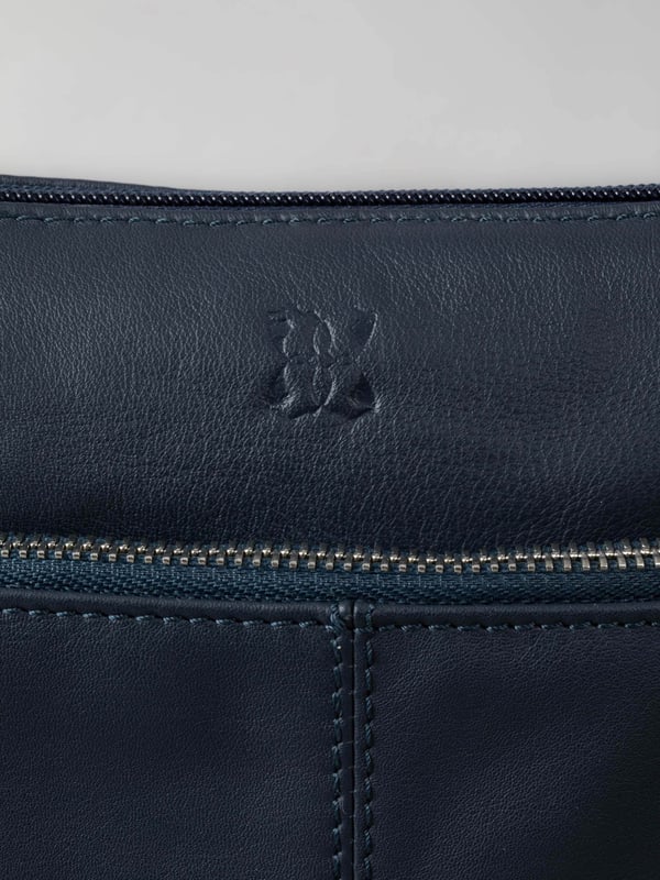 Welcome portable style into your handbag collection with the slimline yet pocket-packed Enderby cross body bag in easy-to-style navy.Crafted from soft and smooth leather, this bag features a large front zip and rear zip pocket on the outside for easy access valuables, and the interior boasts zip and slip pockets to ensure you stay organised on the go.The adjustable shoulder strap makes the Enderby ideal for everyday use, big enough for your essentials but superbly lightweight.The DetailsStyle: Enderby Leather Cross Body BagColour: NavyMaterial: LeatherDimensions: W22 x H24 x D2cmAdjustable leather strapAdjustable strap drop: Max 76cm - min 36cmZip top fastening with leather pullerLarge front zip pocketRear zip pocket And On The InsideOne zip pocketOne slip pocketFabric lining