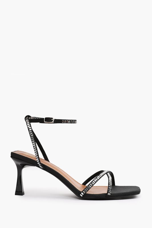 Introduce a touch of glamour to your footwear collection with our Luisa Square Wide fit Toe Low Block Heel with Diamante Cross Over Strap Detail. These heels are the epitome of elegance and sophistication, making them the perfect finishing touch to any outfit, whether it's for a formal event, a night out, or a special occasion.Key Features:


Exquisite Design: The square toe silhouette of these high heels exudes a timeless appeal that never goes out of style. Enhanced by the diamante detail strap, these shoes are guaranteed to make heads turn.

High-Quality Construction: Crafted from premium materials, these high heels are designed to last. The high-quality construction ensures long-lasting durability while maintaining the comfort of your feet.

Specifications:

Closure: Ankle strap with buckle.
Heel Height: 3.3' (8.3cm) approx

Invest in our Luisa Square Wide fit Toe Low Block Heel with Diamante Cross Over Strap Detail and bring that extra touch of elegance and sophistication to your wardrobe. They speak loud and clear of luxury and style – a piece worth showcasing!