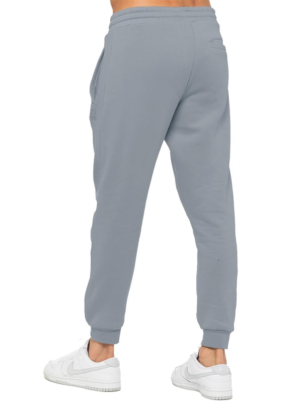 Experience ultimate comfort in our Enzo Mens Regular Fit Joggers. Made with a soft brushed back inner fleece lining, these joggers are perfect for casual wear. The cuffed leg design and elasticated waist with drawstrings provide the perfect fit. With 2 side slash pockets, you can easily carry your essentials.