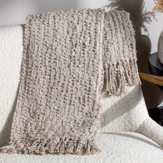 Add instant style and texture to any space with the Arvo throw. This woven design is adorned with elegant strands of vertical boucle yarn, which slide gracefully down the piece, until they meet the textural fringing at both ends. It comes in a range of muted, chic tones, which are inspired by modern neutrals and fashion fabrics. A simple, but polished throw to drape on your sofa or bed to add instant style and texture to your home.