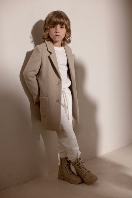 Introducing the Boys Imaril Long Coat in Beige, a quintessential piece by Trussardi for your boy's Back To School wardrobe. Here are the key highlights that make it a standout piece: Smart Aesthetics: The coat's elegant design in a soothing beige hue exudes sophistication, ensuring your boy steals the show.Premium Quality: Crafted from superior quality materials, this coat provides optimal comfort and warmth, making it a perfect choice for chilly days. Designer's Edge: Exclusively from Trussardi, this coat is a representation of high-end fashion and style, essential for an impeccable look. Order now and let your boy create a style statement!