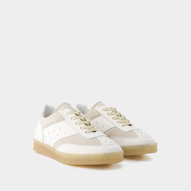 De MM6 6 Court Sneakers Maison Margiela belichamen casual elegantie met hun strakke witte leren ontwerp. Ontworpen om stijl en comfort te combineren, zijn deze sneakers voorzien van de verfijnde handtekening van het modehuis en geven ze een eigentijdse touch aan elke outfit. De 6 Court Sneakers zijn perfect voor een verfijnde urban look en weerspiegelen de avant-gardistische esthetiek en uitzonderlijke kwaliteit van het merk. Kleuren: Wit - Blanc. Hoofdmateriaal: generfd kalfsleer. Materiaal zool: rubber. Materiaal voering: leer. Sluiting: veters bovenaan. Tipvorm: rond. Pasvorm: op maat - Maatvoering: Europees.