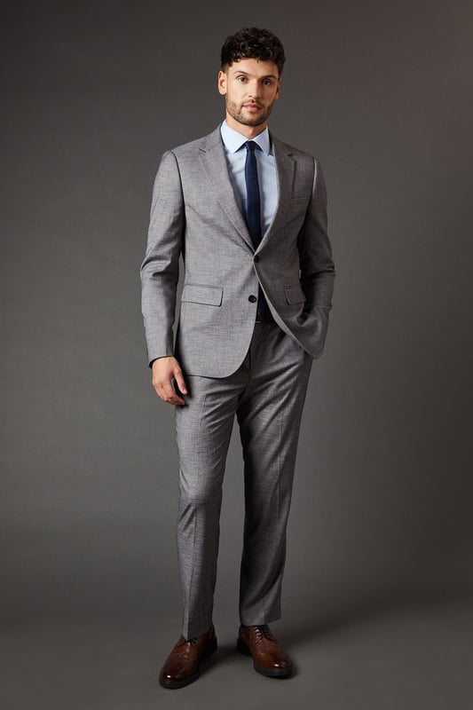 Slim fit design for a modern, tailored silhouette
        Sharkskin texture adds subtle depth and interest
        Notched lapels and two-button closure for classic styling
        Flap pockets and chest welt pocket for practicality and style
        Versatile mid-grey hue suitable for various occasions
    
    This Burton slim fit suit jacket radiates sophistication and versatility, perfect for the modern gentleman who appreciates timeless style with a contemporary edge. The sharkskin texture lends a subtle depth to the fabric, catching the light in a way that adds intrigue to your ensemble. Pair it with the matching trousers for a complete look that's ready for the boardroom, or dress it down with dark denim for smart-casual events. The jacket's slim cut flatters the physique, creating a sharp silhouette that's ideal for everything from important business meetings to after-work drinks with colleagues. Accessorise with a crisp white shirt and a bold tie to make a statement, or opt for a light blue shirt for a softer approach. This versatile piece is a wardrobe essential for the man who moves effortlessly between professional and social settings, always looking impeccably put together.