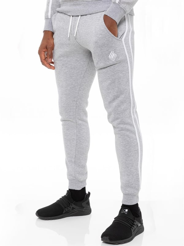 Enzo Mens Tape Hoodie Full Zip Tracksuit. Zip Through Hooded Top. Enzo Embroidery Logo on Chest and Contrast Stripe Design on Sleeves. Hoodie with Drawstring. Ribbed Waist and Cuffs. Kangaroo Pockets. Enzo Mens Casual Designer Striped Tracksuit Joggers. Featuring Classic Contrast Stripes to Sides. 2 Side Pockets. Cotton Blend for Superior Comfort. Adjustable Waist with Drawstrings. Athleisure Perfect for All Gym wear