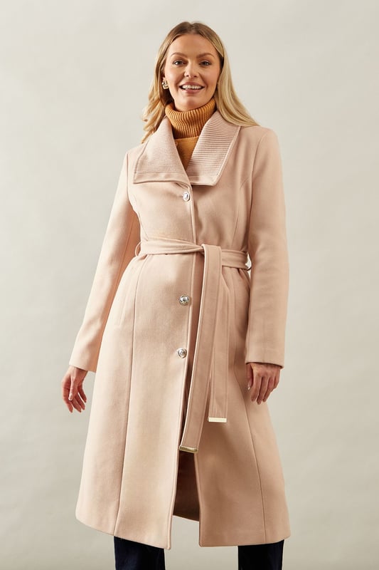 Elegant knitted collar for added sophistication
        Wrap design with button-through closure for versatile styling
        Long length offers maximum coverage and warmth
        Belted waist creates a flattering silhouette
        Functional side pockets for practicality
    
    This Wallis Knitted Collar Button Through Wrap Coat is the epitome of refined elegance. Perfect for the woman who appreciates sophistication without compromising on comfort, this coat is a versatile addition to any wardrobe. The wrap design allows for customisable fit, while the button-through closure adds a touch of classic charm. Style it over a sleek midi dress and pair with heeled boots for a polished look at formal events. For smart casual occasions, layer it over tailored trousers and a fine knit jumper, completing the ensemble with leather ankle boots. The long length and belted waist not only provide warmth but also create a striking silhouette that's sure to turn heads. Whether you're attending a business meeting or heading to a sophisticated dinner, this coat will ensure you look impeccably put-together while feeling effortlessly comfortable.