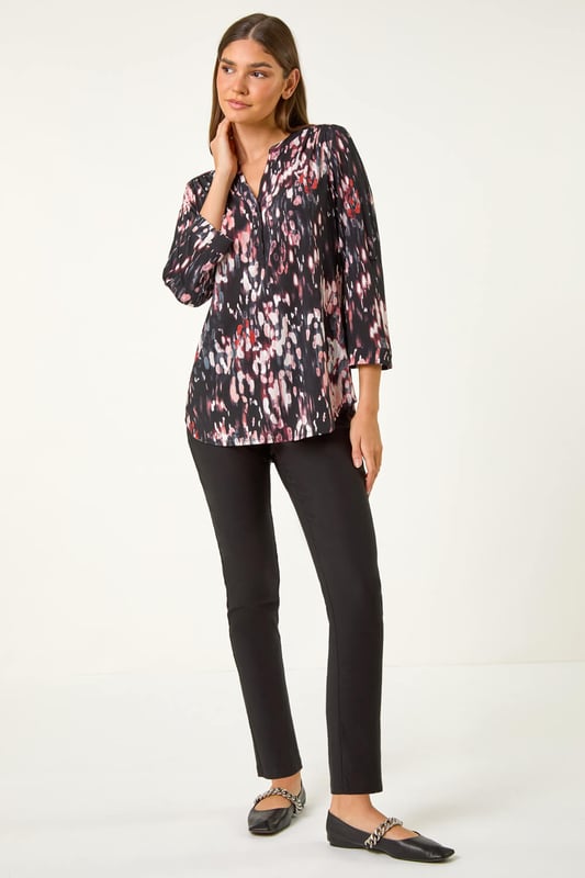Textured Abstract Print V-Neck Stretch Top from Roman. Unleash your signature style this Autumn Winter with our abstract print shirt. Designed in a soft, stretchy jersey fabric, this shirt features a striking 3D abstract puff print for an eye-catching look. The flattering v-neckline adds a touch of sophistication, while the shoulder pleat details, front button fastenings, and 3/4 length tabbed sleeves create a trendy finish. Style with jeggings and ankle boots for both casual and smart occasions!