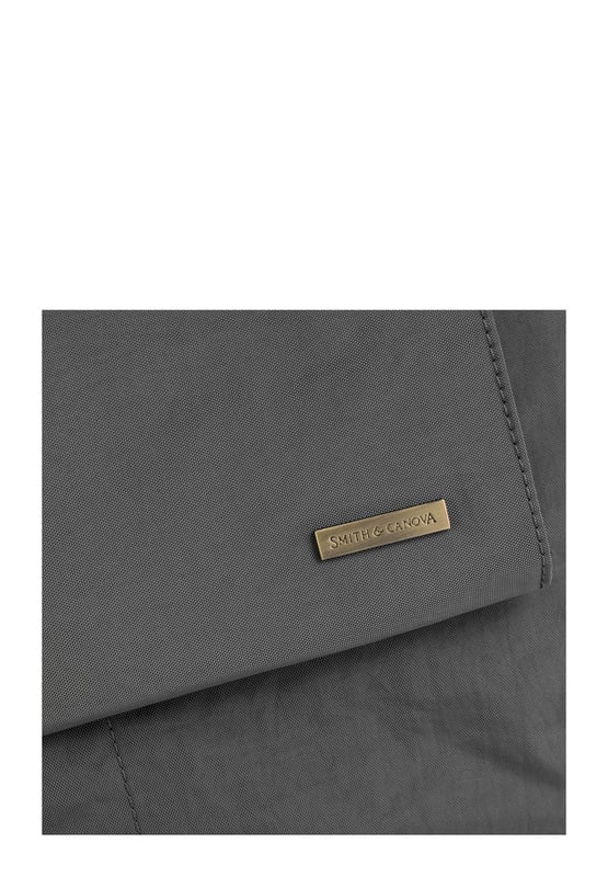 The Landscape Nylon Tote is the perfect commuter bag. With ample internal space and an oversized flap over zip pocket to the front, the bag features a comfortable padded carry handle and adjustable crossbody strap with clip off function. Features: , Zip top opening, Front oversized flap over zip pocket, Rear zip pocket, SMITH & CANOVA antique brass logo, Branded antique brass zips, Padded grab handle, Adjustable crossbody strap (detachable), Internal 15 inch padded laptop sleeve, Internal zip pocket, 2 Internal mobile phone slip pockets - fits normal and plus size smart phones, 3 Internal pen slip pockets Style Ref: 92683 DKGREY