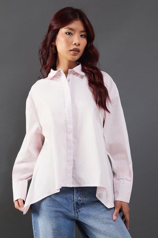Striking open back design with tie detail
        Classic collared neckline for a polished look
        Long sleeves with button cuffs for versatility
        Relaxed fit through the body for comfort
        Crafted from breathable cotton poplin fabric
    
    Make a statement with this eye-catching poplin shirt from Warehouse. The open back design with delicate tie detail adds an unexpected twist to a classic silhouette, perfect for those who want to inject a bit of edge into their wardrobe. The relaxed fit and breathable cotton fabric ensure all-day comfort, while the collared neckline maintains a smart appearance. Style this versatile piece with your favourite denim for a casual daytime look, or dress it up with tailored trousers for a chic ensemble suitable for family gatherings or brunch with friends. The long sleeves can be rolled up for a more relaxed vibe, making this shirt adaptable for various occasions. Pair with flat sandals or trainers to complete your effortlessly cool outfit.