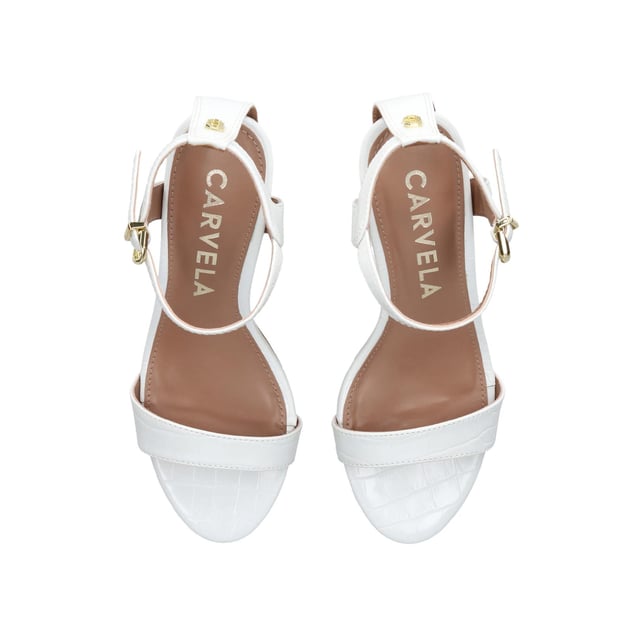 The Carvela Kiki is a block heeled sandal. The upper is in a bone snake embossed design with open toe. The ankle is fastened with gold tone buckle and features an Icon C stud. Heel height: 80mm