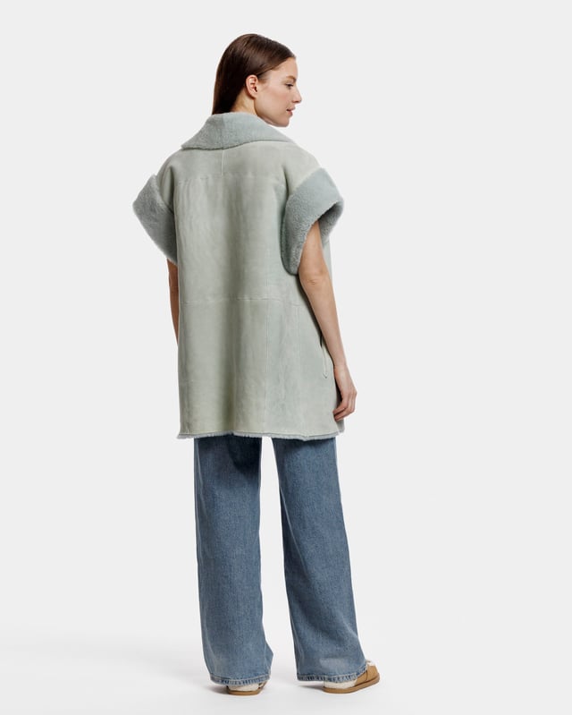Een oversized gilet van echt schapenvacht. Het gilet is volledig omkeerbaar, voor twee verschillende looks. Zowel aan de pluizige als aan de gladde kant zitten zakken op de heupen.