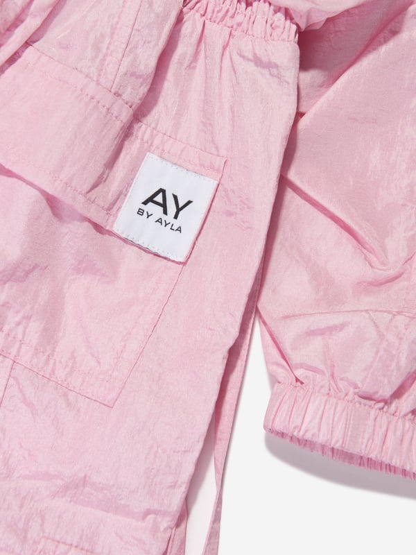 Dream big and feel fab with this girls pink woven jumpsuit from AY by Ayla. The stylish and dramatic piece is a lightweight overall designed to look good with every move. Dance, jump and twirl with effect thanks to an on-trend aesthetic straight out of a music video. Wear over light layers for a cool and chic look. Front Zip Fastening Elasticated Cuffs Elasticated Waistband Elasticated Toggle Ankle Cuffs 2 Side Zip Pockets 2 Chest Pockets 2 Cargo Pockets 2 Back Pockets