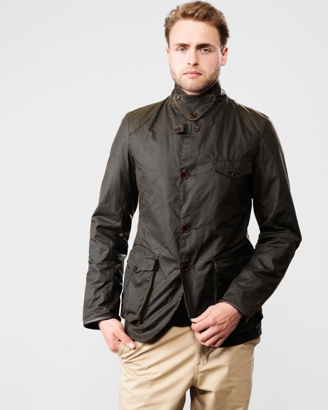 Barbour Beacon Sports Wax Jacket
As this is a slim fitting jacket, we would advise purchasing the next size up than you would normally choose. The three-pocket waxed Beacon Sports jacket is an iconic blazer-style button through, inspired by the sought-after, limited edition To Ki To Sports Jacket. Effortlessly stylish and easy to wear, the Beacon Sports Jacket is a mediumweight waxed cotton jacket featuring soft leather-bound cuff edges, shoulder and elbow patches, two zipped rear pockets and a button-up throat flap. Lined with Barbour tartan, this jacket reflects traditional Barbour elements, with classic hip-height bellows pockets and a single chest pocket. This jacket is surprisingly versatile, and looks great worn as a blazer with the collar folded down and lapels open, or with the collar turned up worn over a fine-knit jumper and scarf for a contemporary country look.

Tailored Fit
Barbour tonal embroidery to left pocket
Outer: 100% cotton (waxed)
Lining: 100% cotton
Trim: 100% wool
6oz waxed cotton
Do not wash
Sponge clean only
Back length: 69cm - 81.5cm

MWX0007
