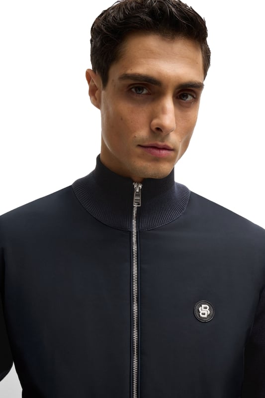 Boss C-Darmando Mixed-material Zip-up Jacket Dark Blue
 
A signature zip-up jacket, cut to a straight fit and crafted in mixed materials for ultimate style and performance. Finished with the all new double-monogram badge at the chest.

Regular fit
Ribbed cuffs
Standard length
Quality: 100% Cotton, Sleeve: 71% Cotton, 29% Polyester, Front panel: 100% Polyester, Front lining: 100% Polyester, Ribbing: 79% Cotton, 21% Polyester, Wadding: 100% Polyester (80% recycled)