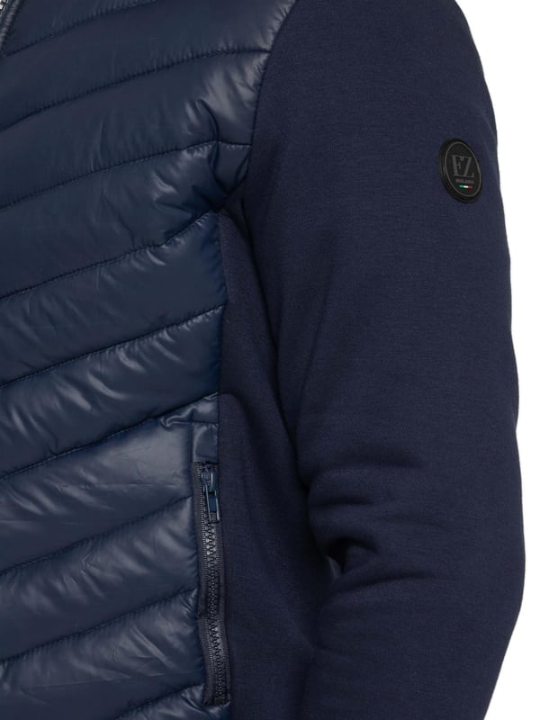 Enzo Milano Mens Hybrid Jacket features a puffer front made from lightweight polyester, which provides excellent insulation. Full zip fastening front with a elasticated collar, long contrast-fabric sleeves with elasticated cuffs. The jacket has 2 secure zip-fastening pockets, 2 inside pockets for additional storage. Finished with Enzo Milano rubberised branding on the left sleeve.