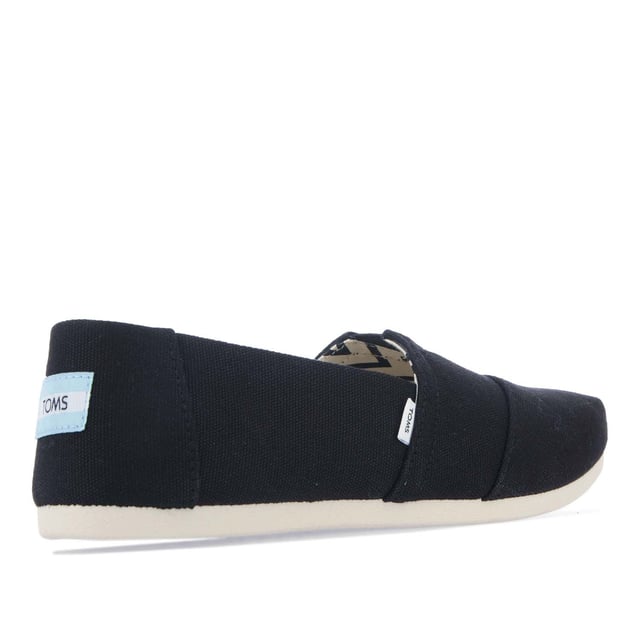 Espadrilles Toms Alpargata en coton recyclé pour femme en noir.- Dessus, doublure et semelle de propreté en coton recyclé composés à 50 % de coton recyclé.- Couture à la pointe et V élastique pour se chausser et se déchausser facilement.- Design Alpargata classique.- Gore élastique pour se chausser et se déchausser facilement.- Semelles intérieures personnalisées fabriquées avec 50 % d'éco-contenu, y compris de la mousse PU recyclée.- Semelle extérieure durable et flexible liée directement à la Dessus via Construction en TPR à injection directe pour un ajustement sans couture.- Logo Toms sur le côté et à l'arrière du talon.- Construction 100 % vegan.- Dessus en textile, doublure en textile, semelle en textile et synthétique.