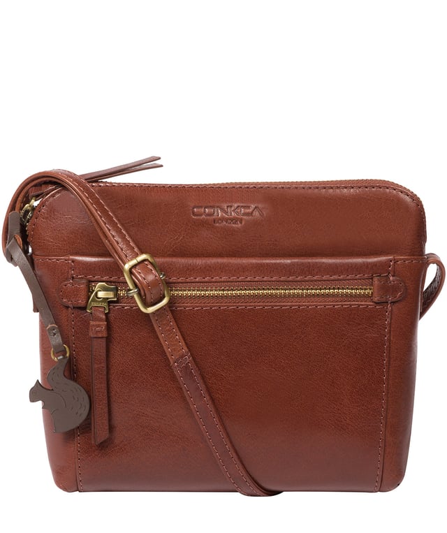 Handcrafted from natural leather, the 'Frida' cross body bag from Conkca London has a beautiful finish. A zip-over top secures a central compartment which is lined with 100% natural cotton and includes two slip pockets - ideal for a phone and keys. On-the-go storage is provided by spacious zipped pockets on the front and back of the bag alongside a slip pocket. This accessory is finished with a slim and adjustable leather strap and adorned with the inimitable Conkca squirrel logo and charm.