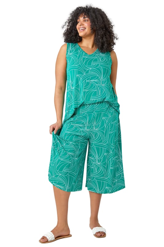 Curve Abstract Swirl Stretch Cropped Culottes from Roman. Say hello to your new favourite staple piece in a bold abstract print. Roman Curve's new and stylish wide-leg culottes are everything you need. Soft stretchy jersey fabric and an elasticated waist make these floaty trousers comfortable and wearable throughout the season. Our casual pull-on bottoms are so versatile, wear with our matching top (19292234) for a striking daytime style.
