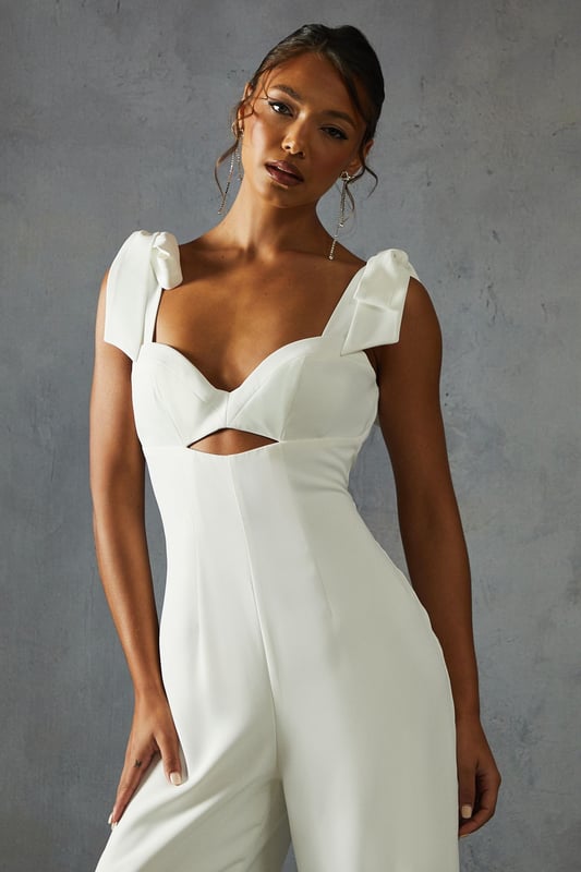 Striking bow shoulder detail for a feminine touch
        Flattering sweetheart neckline with alluring cut-out
        Wide leg silhouette for a dramatic, flowing look
        Square back design adds a modern twist
        Floor-length style perfect for formal occasions
    
    Make a statement at your next special event with this captivating wide leg jumpsuit from Misspap. The eye-catching bow shoulders lend a romantic flair, while the sweetheart neckline and subtle cut-out detail create an alluring silhouette. The wide-leg design flows gracefully to the floor, ensuring a dramatic entrance wherever you go. Style this showstopper with strappy heels and statement earrings for a red carpet-worthy look. Perfect for weddings, galas, or any occasion where you want to turn heads, this jumpsuit offers a fresh alternative to traditional evening wear. The square back adds a contemporary edge, making this piece a versatile addition to your formal wardrobe. Embrace your inner fashionista and let this jumpsuit be the centrepiece of your next unforgettable night out.