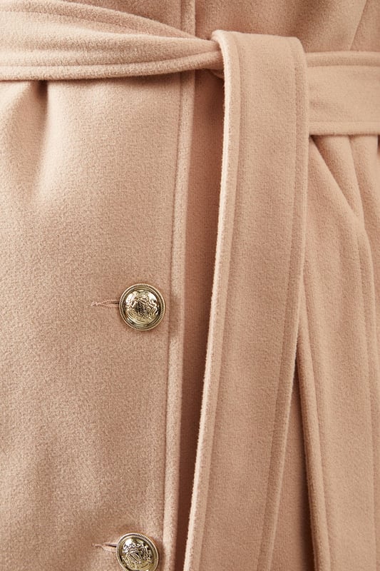 Elegant knitted collar for added sophistication
        Wrap design with button-through closure for versatile styling
        Long length offers maximum coverage and warmth
        Belted waist creates a flattering silhouette
        Functional side pockets for practicality
    
    This Wallis Knitted Collar Button Through Wrap Coat is the epitome of refined elegance. Perfect for the woman who appreciates sophistication without compromising on comfort, this coat is a versatile addition to any wardrobe. The wrap design allows for customisable fit, while the button-through closure adds a touch of classic charm. Style it over a sleek midi dress and pair with heeled boots for a polished look at formal events. For smart casual occasions, layer it over tailored trousers and a fine knit jumper, completing the ensemble with leather ankle boots. The long length and belted waist not only provide warmth but also create a striking silhouette that's sure to turn heads. Whether you're attending a business meeting or heading to a sophisticated dinner, this coat will ensure you look impeccably put-together while feeling effortlessly comfortable.