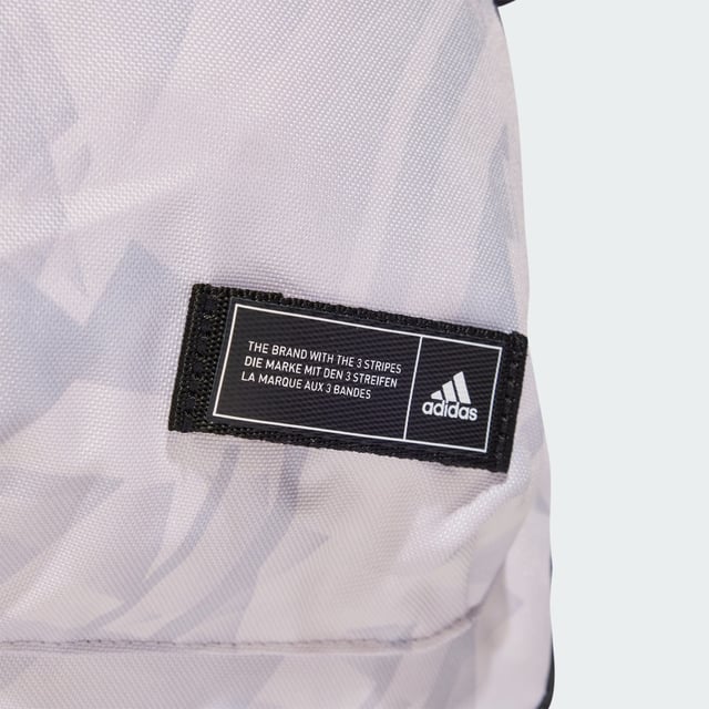 A classic pack with an edgy look. This adidas backpack lends fresh attitude to your casual outfits thanks to a cool allover print. Roomy enough for all your essential gear, it has a zip main compartment, front zip pocket and side slip-in pockets to keep everything organised. Padded adjustable straps add comfort if the bag gets heavy. This product is made with at least 50% recycled materials. By reusing materials that have already been created, adidas help to reduce waste and our reliance on finite resources and reduce the footprint of the products adidas make.  - Dimensions: 15 cm x 36 cm x 44 cm - Volume: 27.5 L - 100% polyester (recycled) - Zip main compartment - Front zip pocket - Side slip-in pockets - Padded adjustable straps  Shipped by adidas