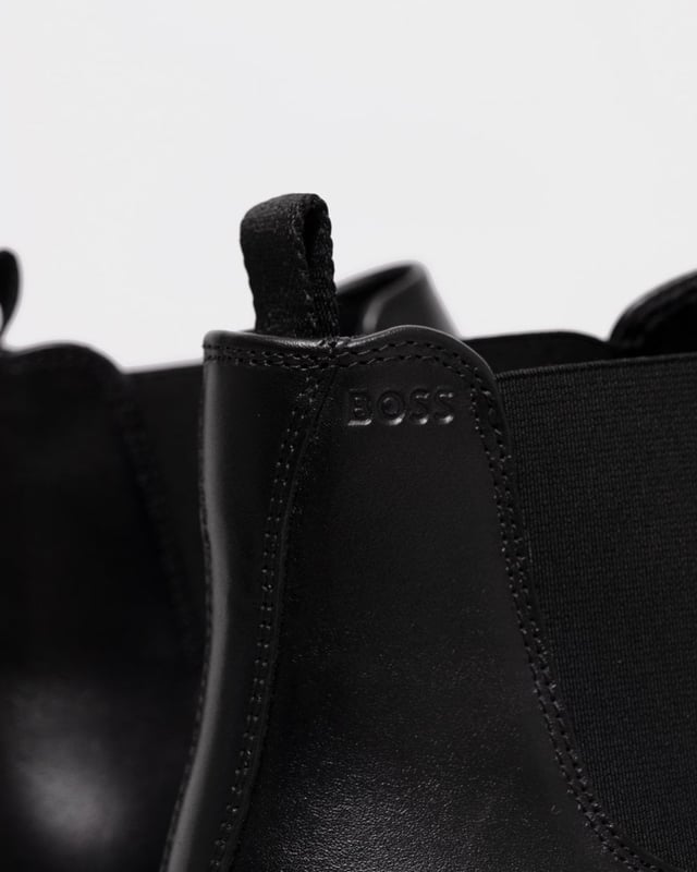 Salga con estilo con las botas Chelsea Theon de BOSS. Confeccionadas con cuero de primera calidad, estas botas negras rezuman un diseño elegante y sofisticado, perfecto para cualquier ocasión. La suela de goma garantiza la máxima comodidad y durabilidad, mientras que la clásica silueta Chelsea añade un toque de elegancia atemporal. Mejora tu colección de zapatos y siéntete como un jefe.