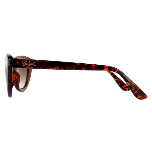 Guess Cat Eye Womens Gold Brown Gradient GF0402  Sunglasses are an alluring cat eye silhouette, adding a glamorous touch to any outfit. Crafted with meticulous precision, the lightweight yet durable frame, adorned with the iconic Guess logo on the temples, embodies a mark of refined taste and quality. Not just a fashion statement, these sunglasses prioritize eye protection, featuring high-quality lenses that offer excellent protection, ensuring both style and safety.