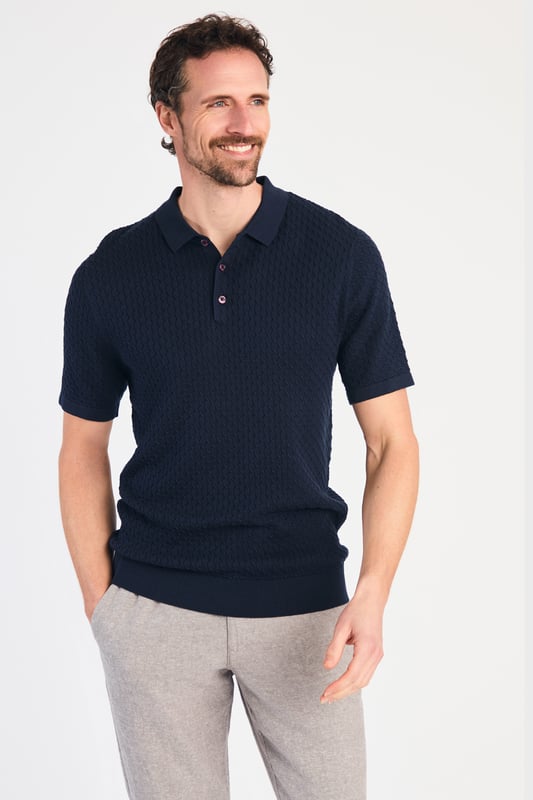 Dark Navy Cotton Short Sleeve Button-Up Polo Shirt This textured polo shirt from Nines Collection blends classic sophistication with modern design. Crafted from a premium cable fabric with a subtle pattern, it offers a refined yet contemporary look. Lightweight and breathable, it’s a versatile choice for smart-casual occasions, ensuring style and comfort effortlessly. Made from 100% Cotton.