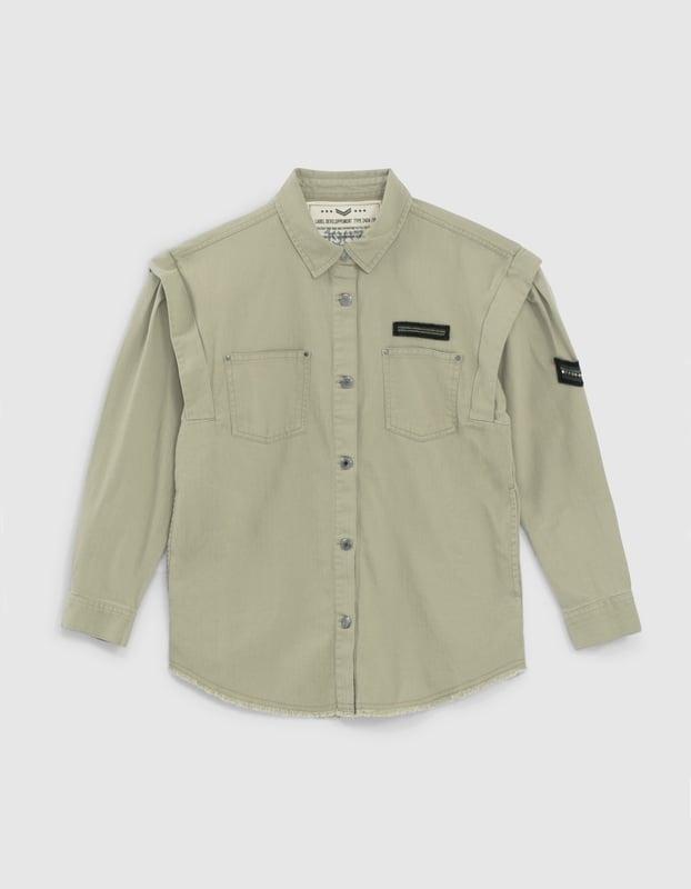 This khaki shirt with removable belt has military badges on the chest and sleeve and two patch pockets on the chest. It has a shirt collar, long sleeves, details at the shoulders and a ripped effect on the bottom. Button fastening.