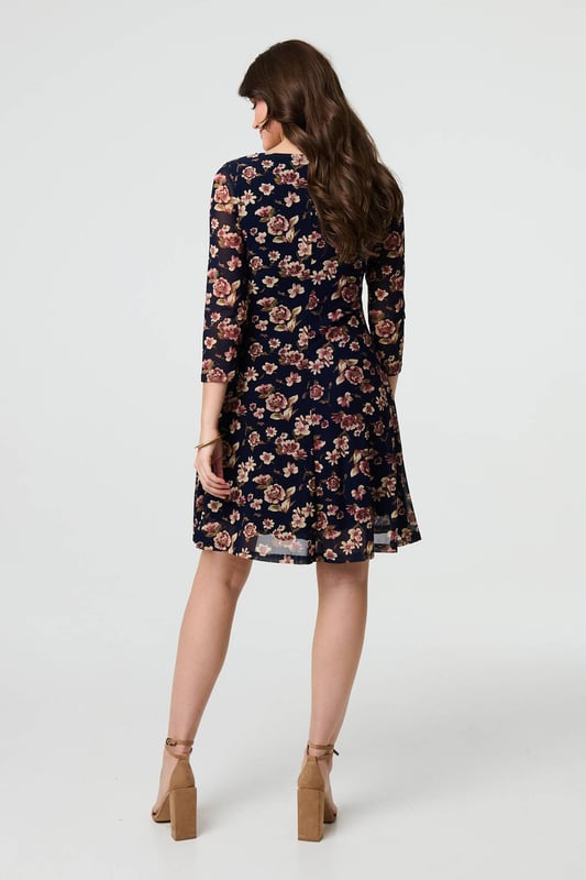 Navy Floral Sparkle Mesh Knee Length Dress You can never have too many floral dresses! This one has a feminine lace layer design, along with a flattering skater fit. It also features 3/4 sleeves, a scoop neck and a knee length hem. Wear with heels for a special occasion such as a wedding or a party.