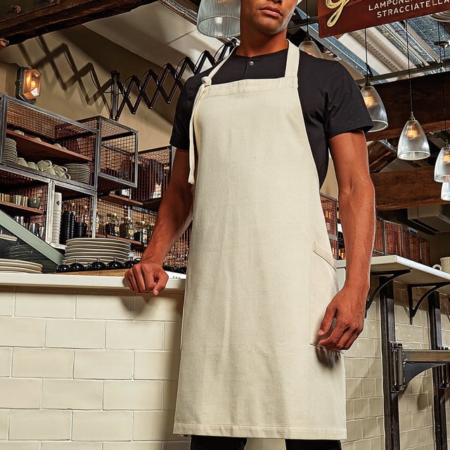 44% Recycled Cotton, 37% Recycled Polyester, 19% Recycled Viscose. Fabric: Denim, Soft Touch, Woven. Length: 86cm. Width: 72cm. Pockets: 2 Side Pockets. Fastening: Adjustable, Buckle, Knotted Strap. Bibbed, Contrast Stitching, Contrast Trim, Neck Band, Self Fabric. Design: Plain. 275gsm. Sustainability: Eco Friendly, Made from Recycled Materials, Oeko-Tex Standard 100 Certified, REACH, Sedex, Sustainable Materials, WRAP Certified.