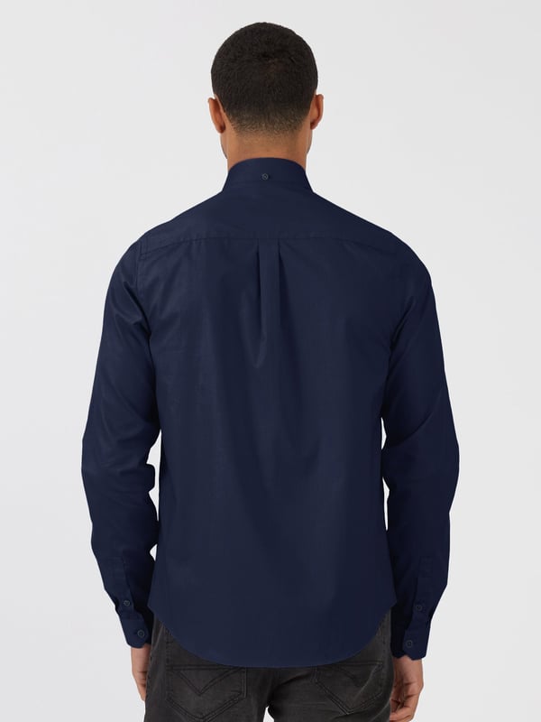 This classic LUKE long sleeved shirt is an essential item for your wardrobe, classically styled with a buttoned-down collar and a simple chest patch pocket. It is detailed with imitation river shell plastic buttons on the central front placket, running from hem to collar and is completed with the brand's iconic lion head embroidery on the left chest. Tailored fit. Iconic LUKE BLACK, GOLD, RED lion head embroidery. Iconic LUKE tri-colour trim tape. Left chest pocket detail-Imitation river shell plastic buttons. Central front placket. Button down collar detail at front and central at back. Back yoke detail and external back box pleat. Long sleeve with buttoned cuff.